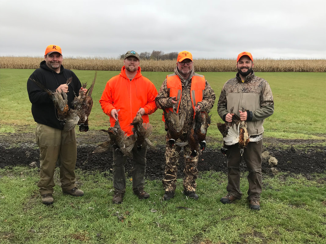 Four hunters with pheasants